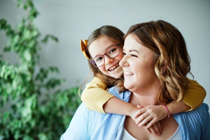 Mamá feliz mientras es abrazada por su hija